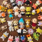 Viele bunte gehäkelte Amigurumi-Figuren auf einem runden Tablett