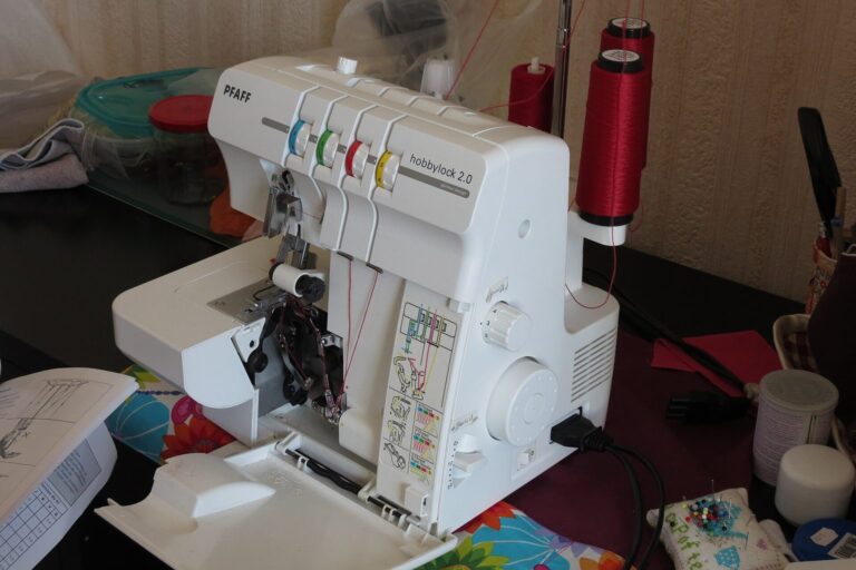 Overlock-Nähmaschine mit farbig gekennzeichneten Fadenwegen auf einem Tisch