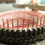 Nahaufnahme einer runden Strickmaschine mit roter Wolle